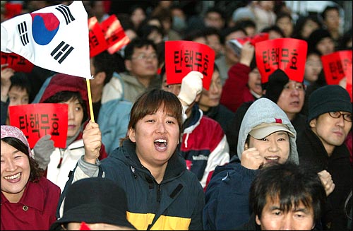 대통령 탄핵안 가결 사흘째를 맞은 14일 저녁 서울 광화문 집회에서 참가자들이 탄핵안 가결의 부당성을 호소하며 구호를 외치고 있다. 